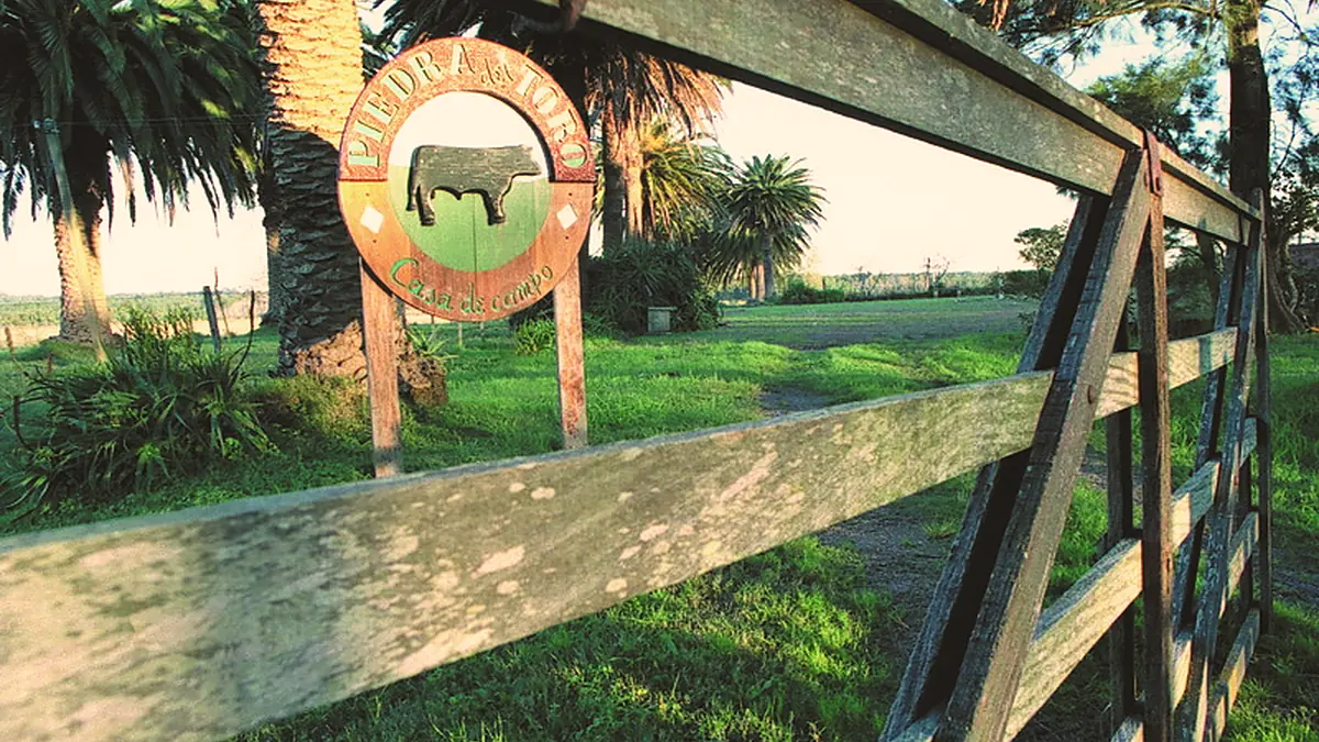 El cartel de entrada de Piedra del Toro sobre la tranquera.